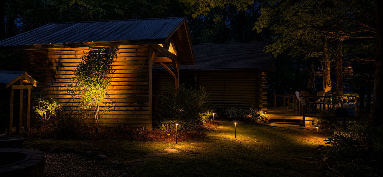 Pathway lights and architectural highlights beside a cabin