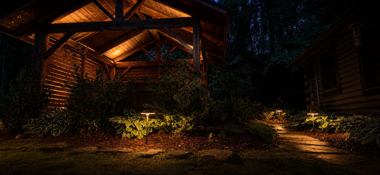 Accent lighting on a timber pergola and surrounding greenery