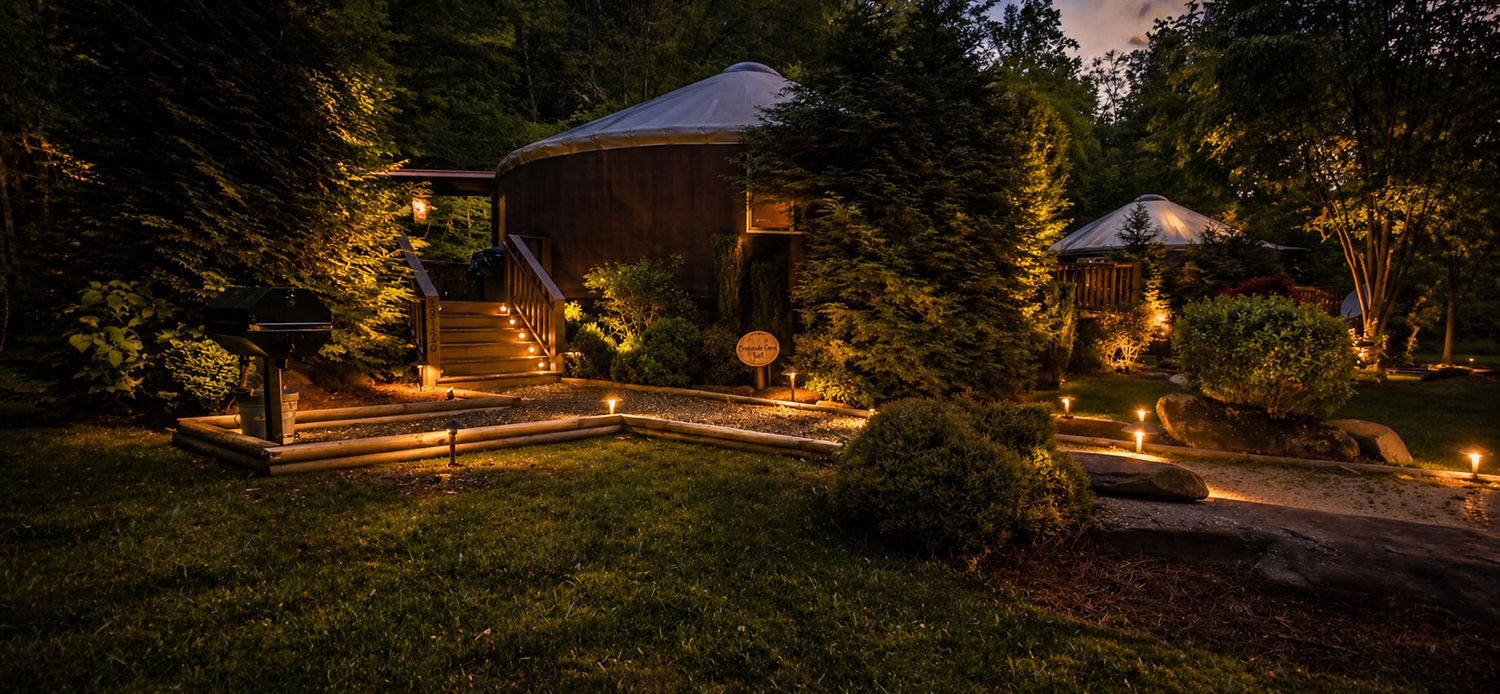 Warm path lighting and tree accents near lodging cabins