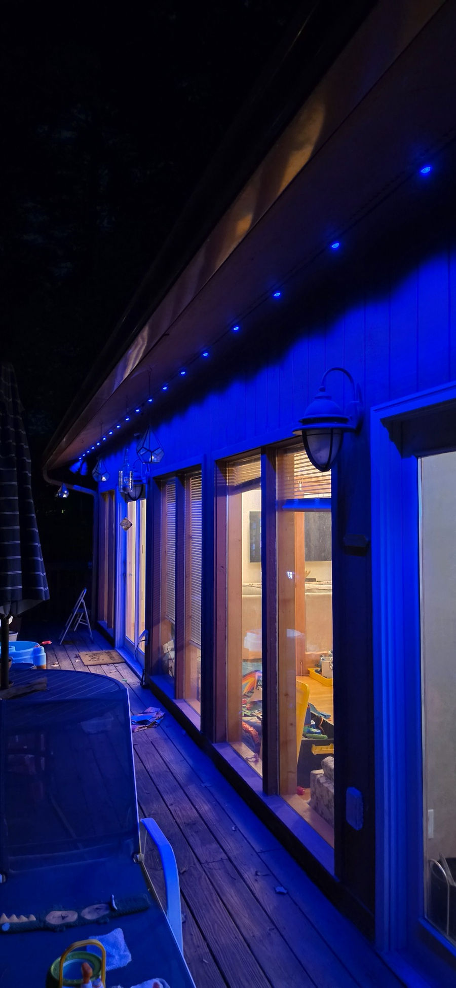 Blue exterior accent lighting above a deck
