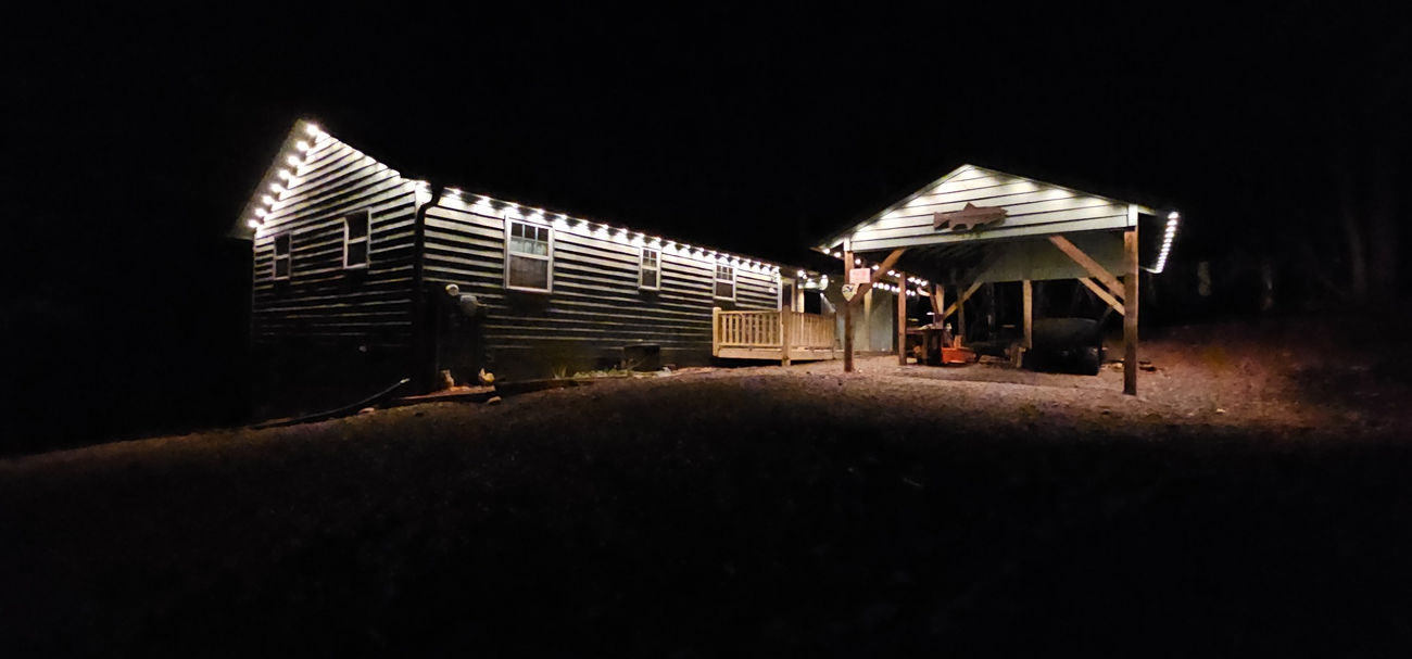 White roofline lighting across a cabin and carport